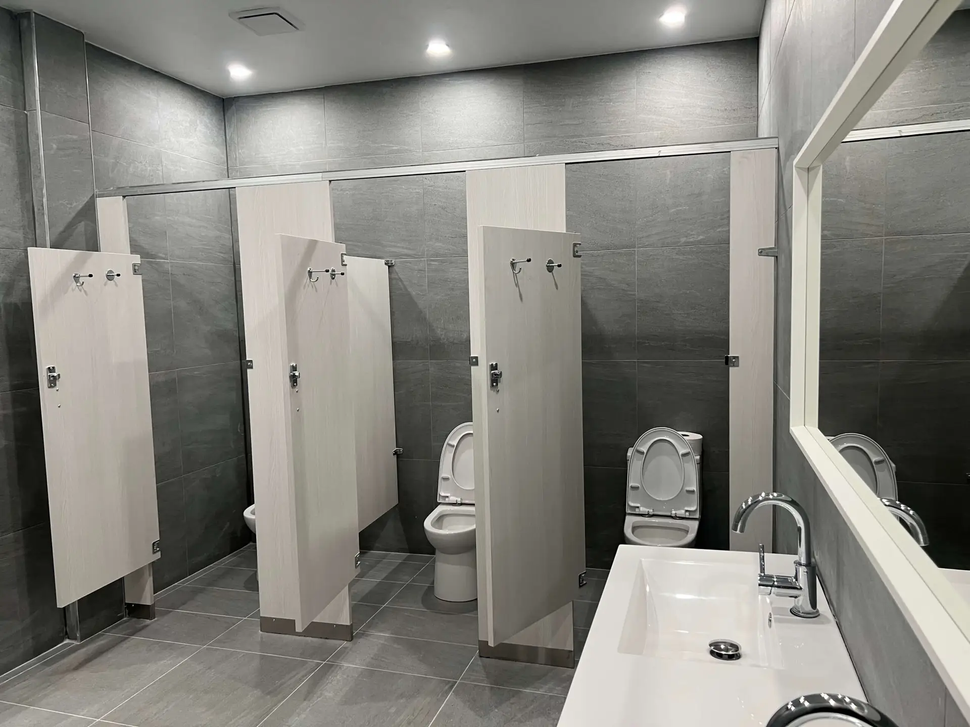 Commercial washroom with toilet partitions by Kodiak Construction Group