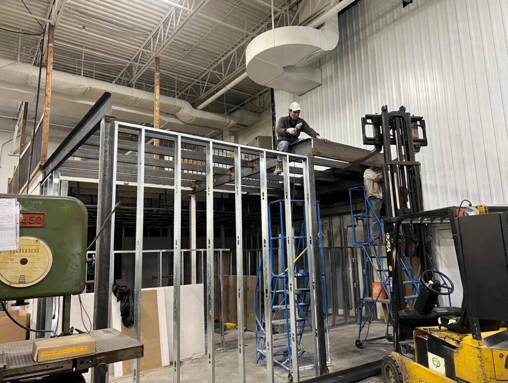 Workers installing structural steel framing inside a commercial building