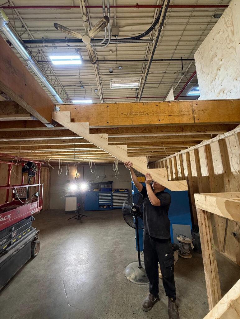 Worker installing an LVL beam during structural framing work