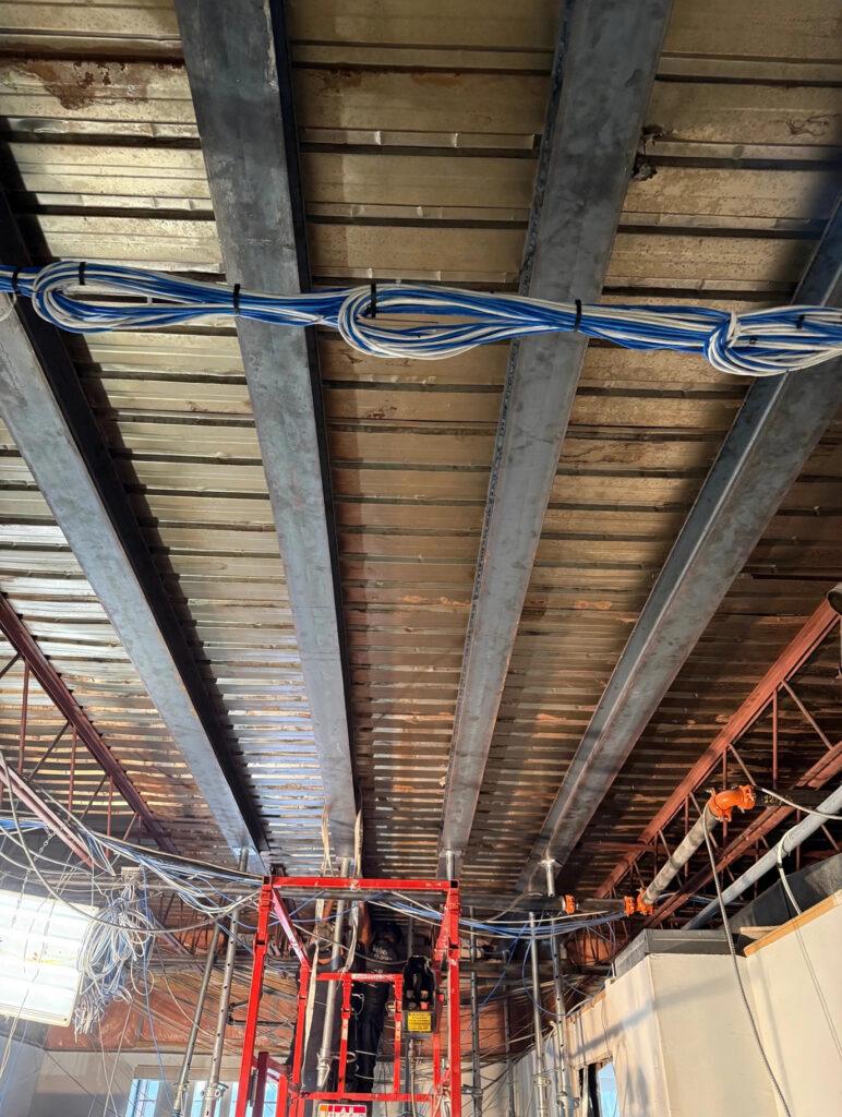 Steel I-beams and metal roof decking with a lift during commercial structural work